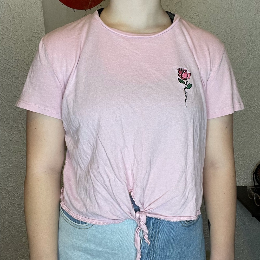 A light pink crop top with a rose in the front